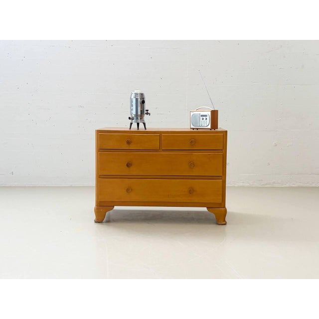 A charming mid-century modern chest of drawers with clean lines and elegant, gently curved legs. The combination of two...