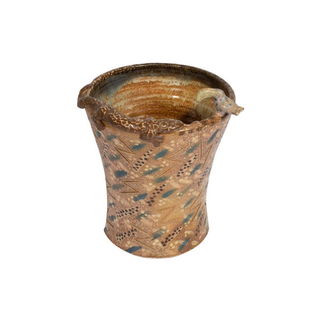 A vintage studio pottery vase ornamented with a small ceramic toucan and salamander. The light brown vessel has a repeated...