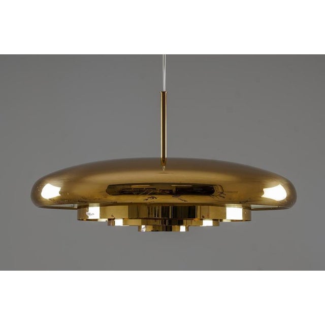 Striking brass pendant designed by Eje Ahlgren for Bergboms in the 1960s. The lamp features a sculptural domed shade with...