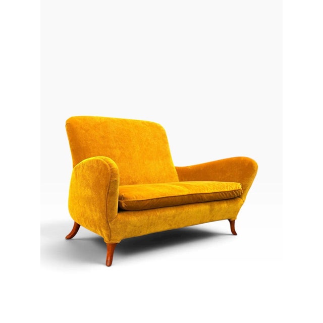 A sculptural Italian two-seat settee from the 1950s, fully restored and reupholstered in a rich saffron velvet. The...
