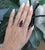 A vivid 12.9CT Rubellite radiates rich crimson fire, encircled by a sparkling halo of earth-mined diamonds. Set in solid...