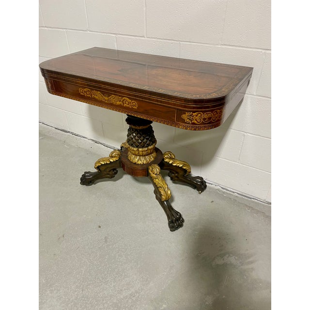 An impressive antique flip-top games table, New York circa 1820. With an impressive figured timber top bordered by an...