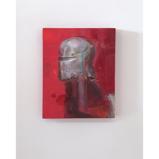 The artwork features a striking depiction of a medieval helmet against a vivid red background, evoking a sense of...