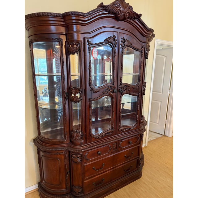 Absolutely stunning large, vintage-style carved wood china cabinet featuring an elaborate traditional design and...