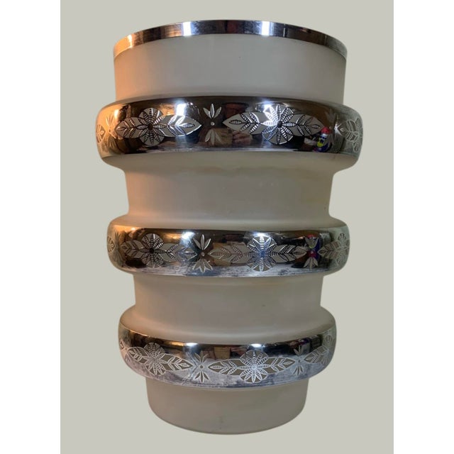 8.25” high 5” wide at top, thick wide bands of sterling silver encompass this very unusual vase. Intricate designs are cut...
