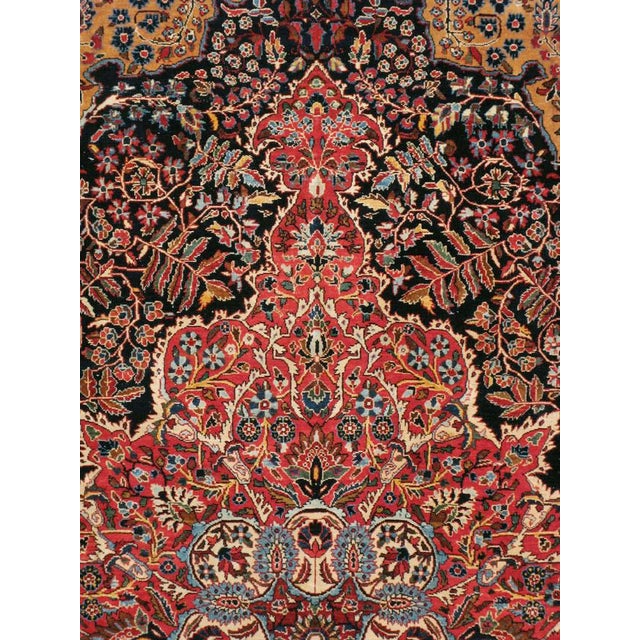 This early 20th-century Persian Sarouk room-size carpet presents a richly detailed central medallion composition in deep...