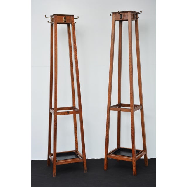 Pair of english arts and crafts / industrial style solid oak coat stands, each having four shaped double hooks to each...