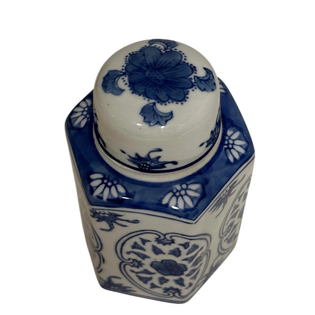 The jar features a traditional blue and white design with intricate floral patterns and a hexagonal body. This jar...