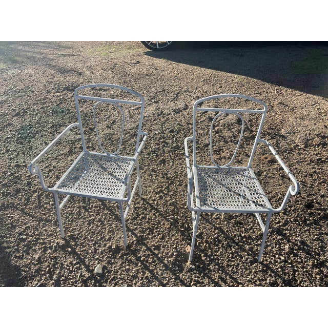 Pair antique cast iron chairs, children’s sized. Seats are pierced. Legs are joined by horizontal stretchers, chairs are...