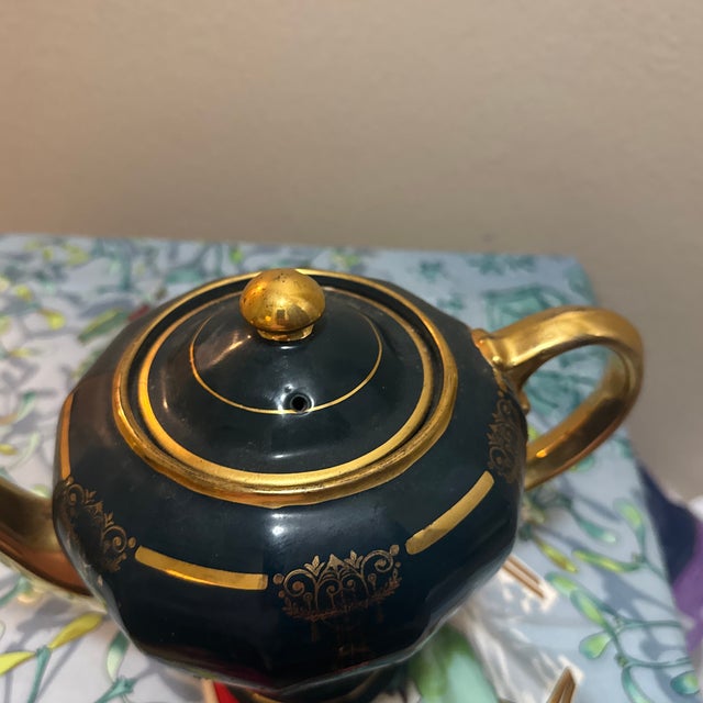 This elegant Art Deco-style teapot features a deep green glaze accented by stunning 22-karat gold-gilded filigree and...