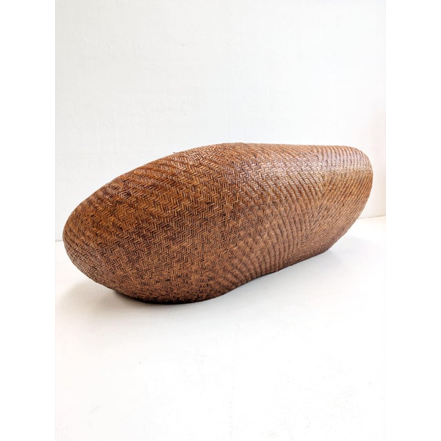 This sculptural rattan sofa, produced by Habitat in the 1970s, features a low, rounded silhouette with softly curved...