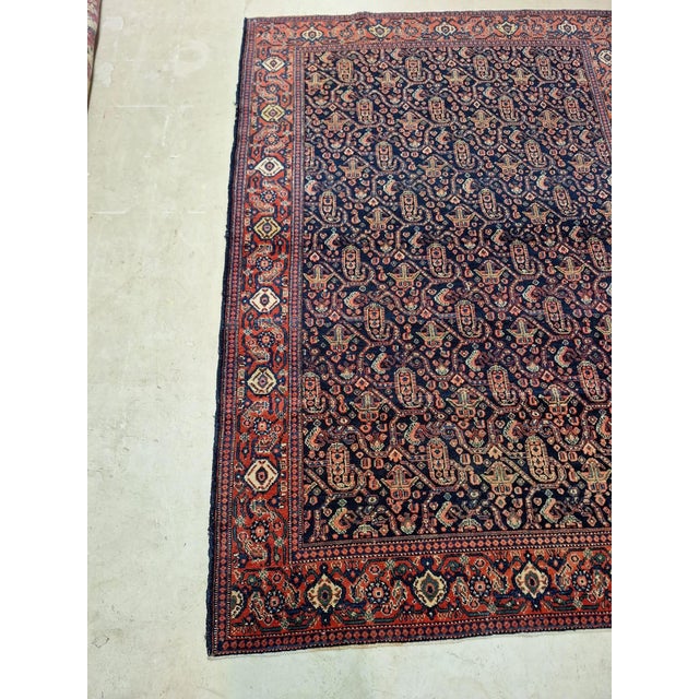 Circa 1920 Persian Senneh Rug navy blue background with raspberry red accent color with a paisley design. Very fine wool...