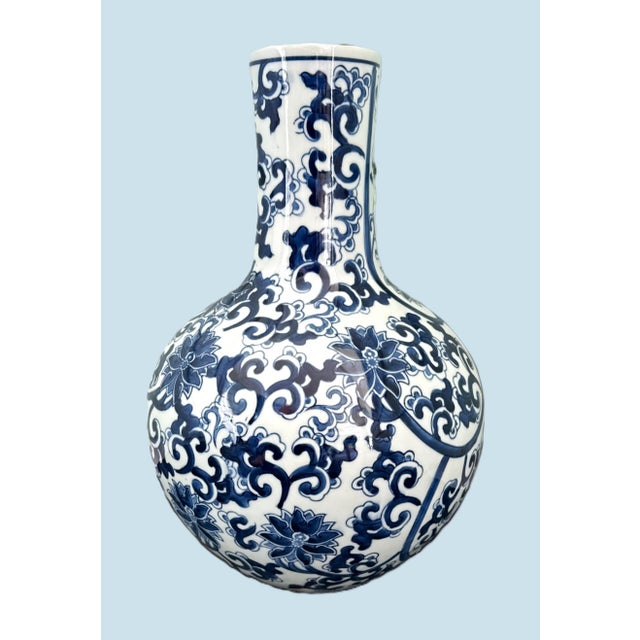 Baluster Vase with Blue Floral Motif This ceramic baluster vase features a harmonious silhouette defined by a rounded,...