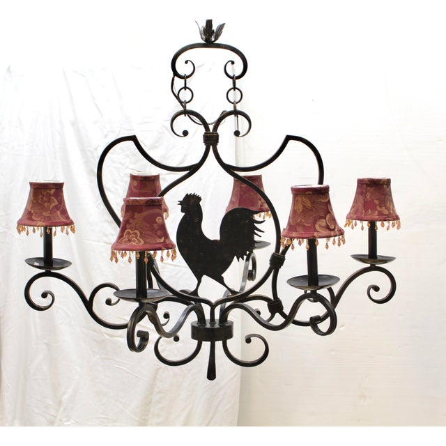 Large vintage wrought iron chandelier features scrollwork and a prominent center rooster silhouette making it ideal for a...