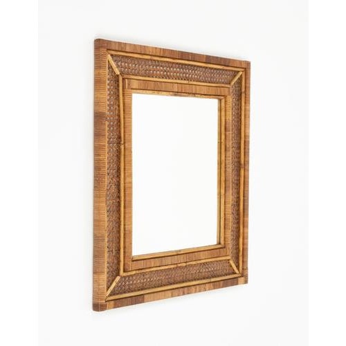 Midcentury beautiful rectangular wall mirror in wicker and rattan. Made in Italy in the 1970s. A highly decorative wicker...