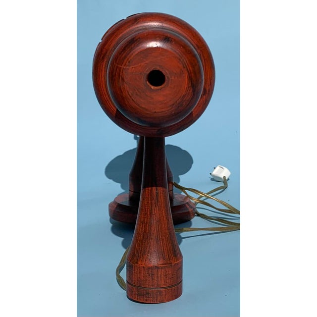 1970s turned column wood wall lamp with red stain varnish and corded thumb switch.