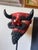 Vintage hand sculpted decorative mask representing devil. The primary red face is constructed from molded paper-mâché or...