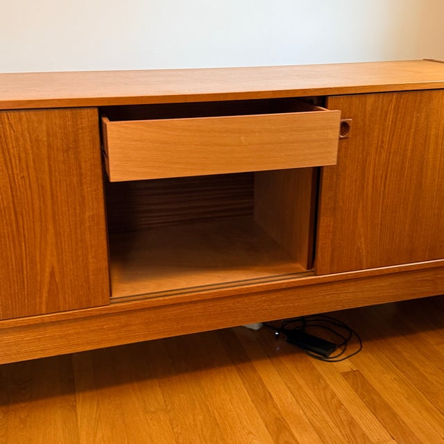 Danish Sideboard with Sliding Doors A simple teak cabinet that is timeless and suitable for any living space. Sliding...
