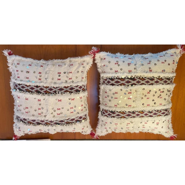 Vintage Moroccan white background handwoven pillows. White with red accents and trip. Ornate fringed red patterned stripes...