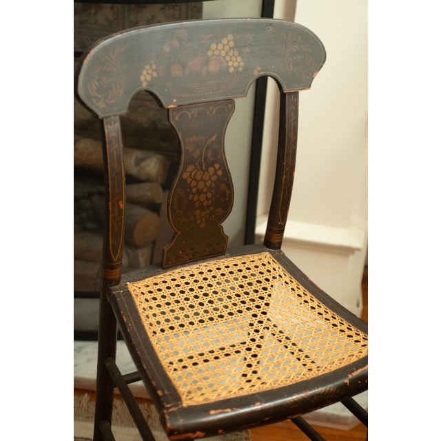 A lovely antique dark brown with gold harvest stencil and patinated finish. Cane seat has probably been recaned as it is...