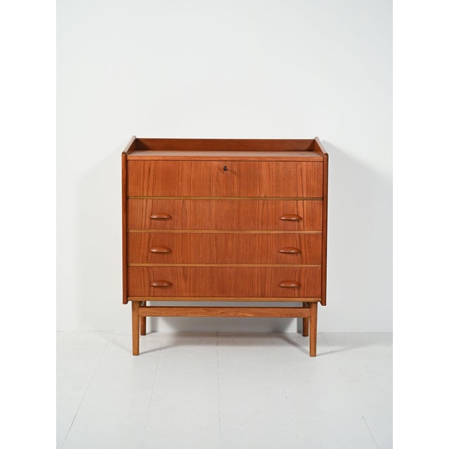 The upper drop-leaf door conceals a dressing table with mirror, opal glass sconces, and original storage compartments;...