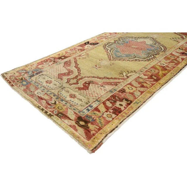 Immersed in Anatolian history and time-softened colors, this hand knotted wool vintage Oushak rug combines simplicity with...