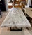 A sophisticated dining table from Origins by Phillips Collection, featuring a sleek straight-edge silhouette and a...