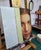 This oil painting captures a moment of introspection, depicting a young woman's face partially obscured by a vertical...