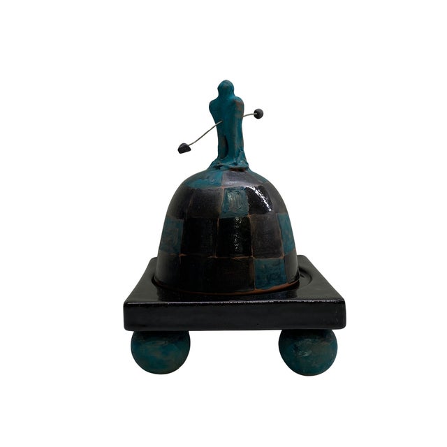 The work features a removable domed cover decorated in a hand-painted checkerboard pattern of glossy black and deep...
