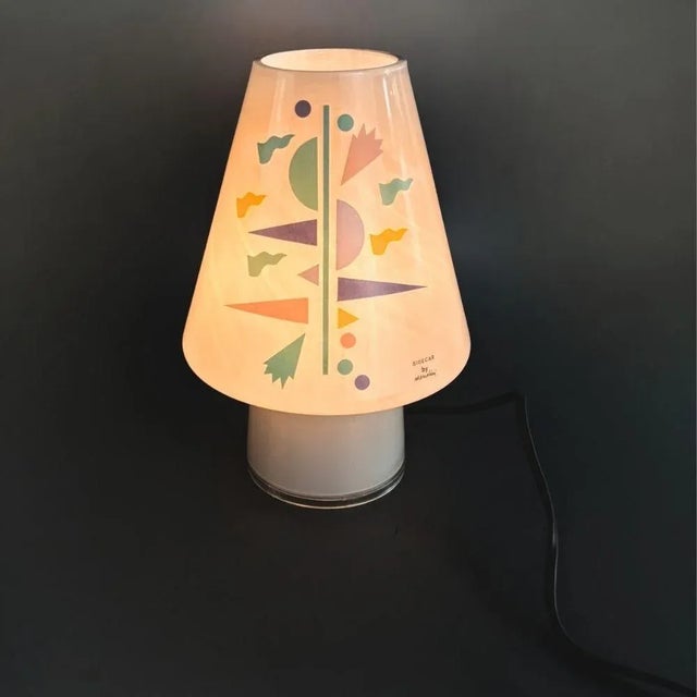A rare collector’s piece from the 1990s, this colorful glass “Bibi” table lamp is an iconic example of Italian design....