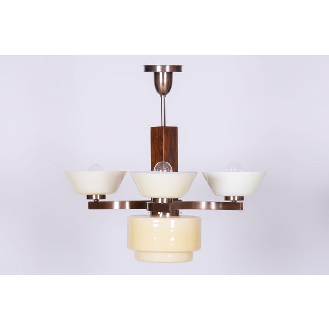 This 4-arm chandelier is a masterpiece of 1920s Czechoslovak Art Deco. The lighting fixture presents a fascinating...