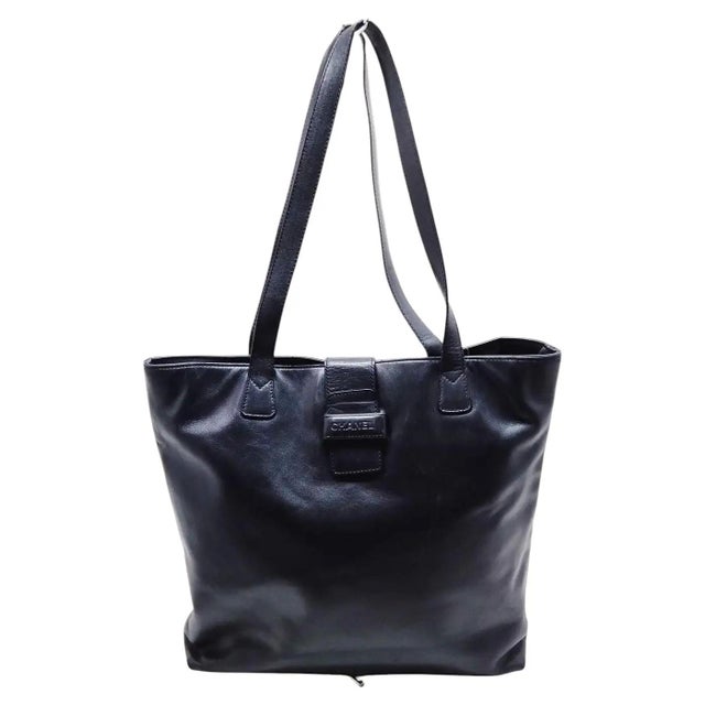 This authentic Chanel tote bag is crafted from smooth, supple black leather, offering a minimalist and highly versatile...