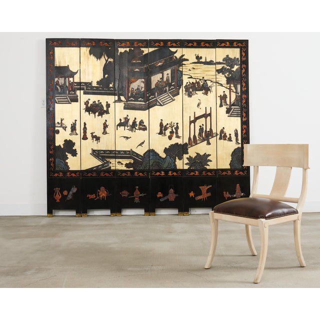 Exceptional 20th century Chinese export six panel coromandel screen featuring a busy idyllic courtyard scene with a...
