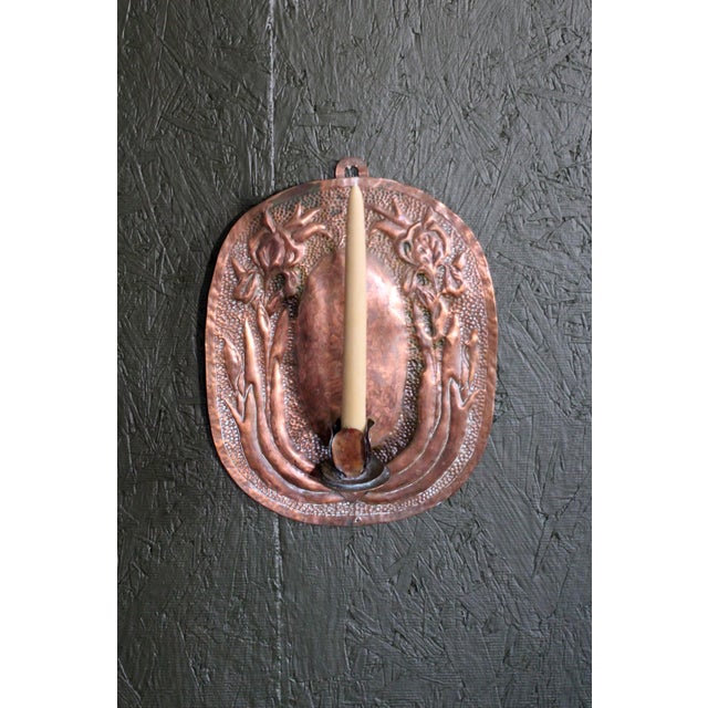 A wonderful Arts & Crafts hammered copper wall candle sconce. Framed on the side with 2 Iris and leaves. Beautiful...