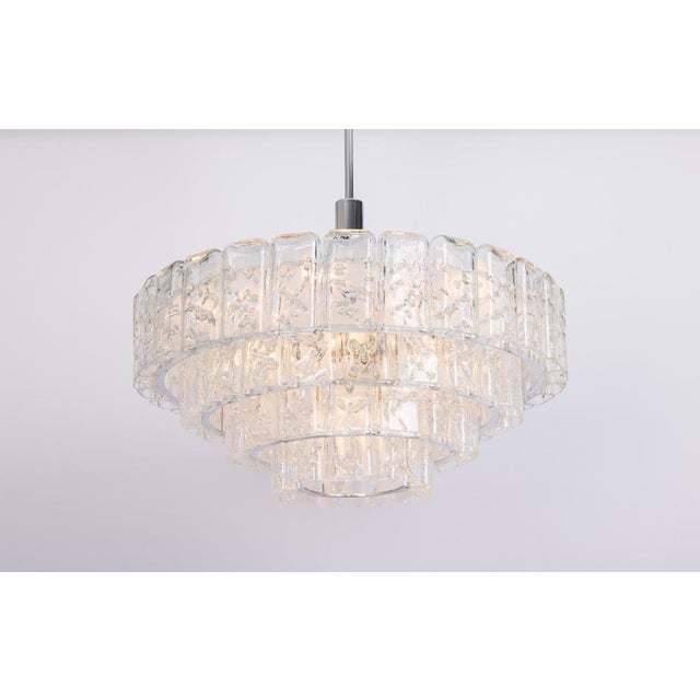 Fantastic four-tier midcentury chandelier by doria, germany, manufactured circa 1960-1969. Four rings of glass cylinders...