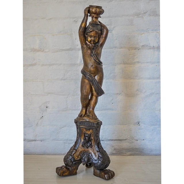 This intricately detailed candleholder is sure to add some whimsical charm to your décor. With a cherub standing on a...