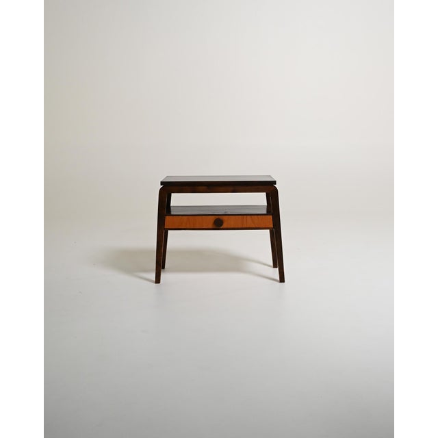 Northern European bedside table with a drawer front, open shelf, and dark wood frame with teak front. 1950s. A...