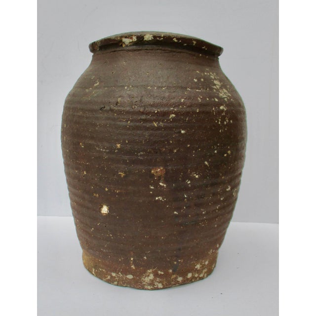 Antique Japanese stoneware storage jar. Hand built with ribs in the wall as the potter raised the thick walls. Built with...