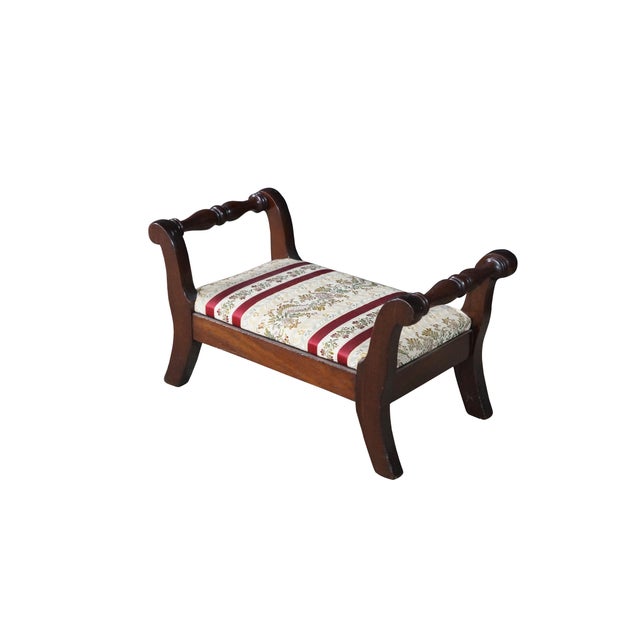 This elegant antique mahogany footstool beautifully showcases the refined proportions and graceful curves of the Empire...