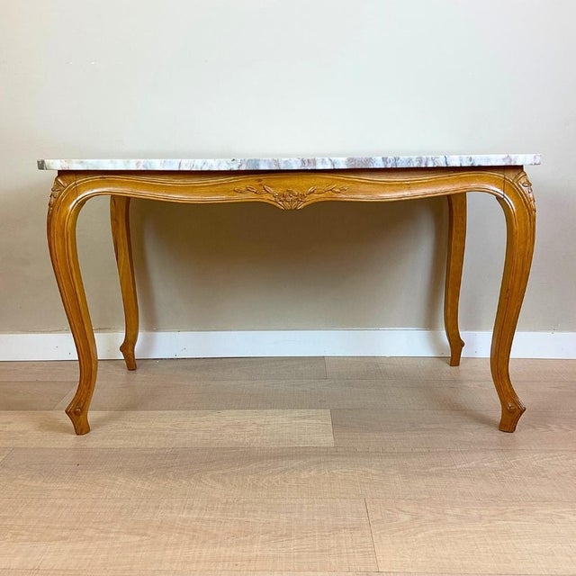 1940s restored Louis XV style coffee table. with carved wooden legs and apron. Shaped marble top with curved edges,...