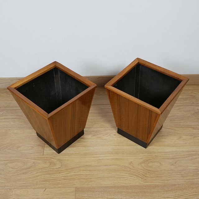 A pair of art deco waste paper bins. Figured walnut with ebonised base and lined interior. Dimensions: h 36cm w 30cm d...