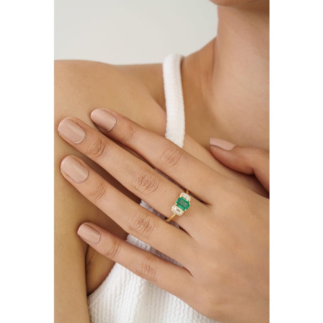 This three-stone ring features a 1 carat octagon-cut emerald and diamond, set in 14K yellow gold. The emerald measuring...