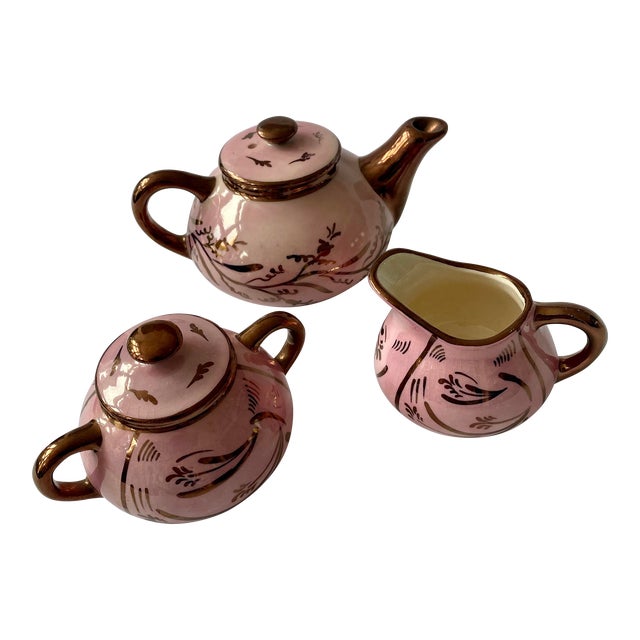 This lovely pink and copper lustreware hand-painted miniature tea set was made in 1940s England. Perfect for a collectible...