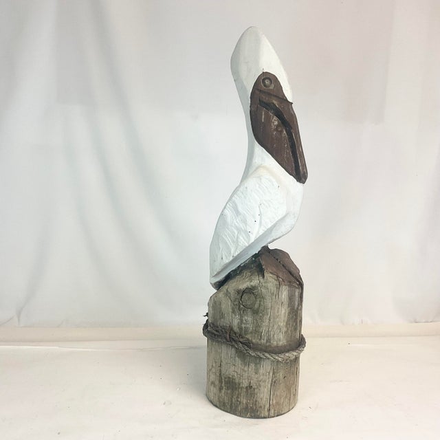 This is a whimsical Americana Folk Art Hand Carved Wooden Sculpture of a Pelican. The Coastal Motif sculpture is crafted...