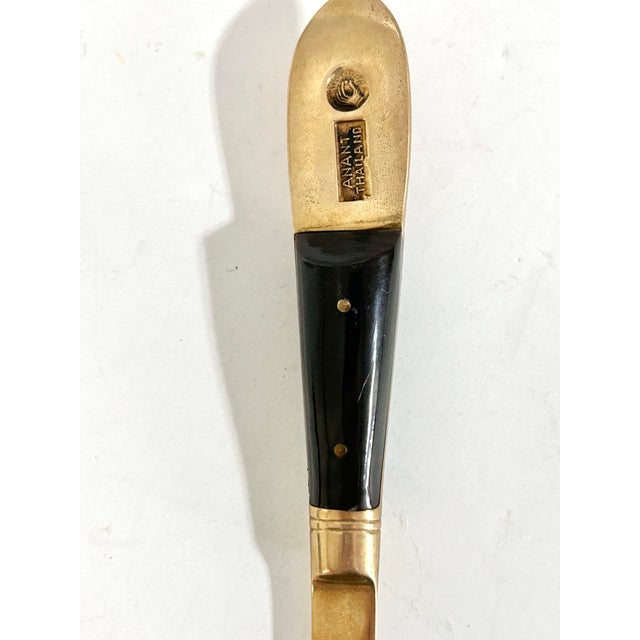 Striking and sculptural, this vintage brass letter opener features an ornate figural handle depicting a traditional Thai...