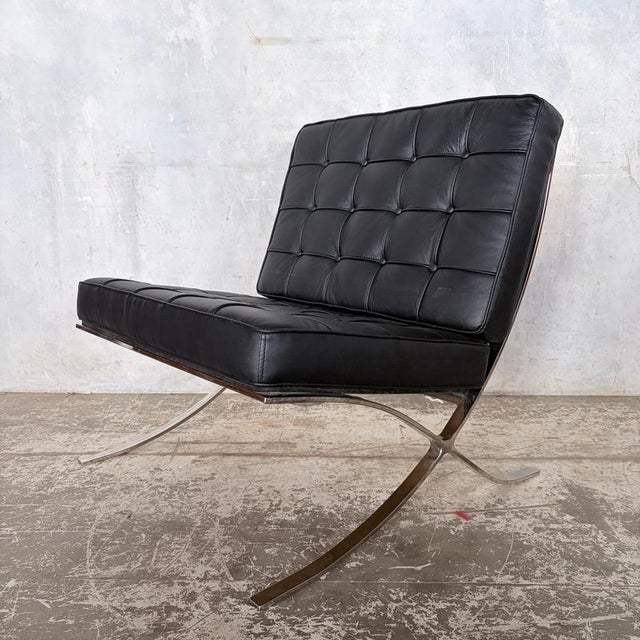 An iconic mid century style Barcelona chair , beautifully upholstered in supple black leather and mounted on a polished...