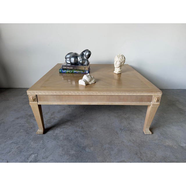 Elegant Hollywood Regency coffee table featuring a refined Neoclassical design with carved Greek Key trim, sculpted lion...