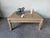 Elegant Hollywood Regency coffee table featuring a refined Neoclassical design with carved Greek Key trim, sculpted lion...