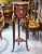 This petite French-style side table features a rich wood finish complemented by delicate gold leaf ornamentation. Its...