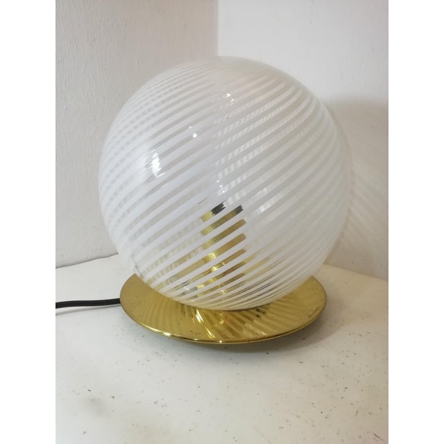 Table lamp by Ornella Noorda for Venini. Brass base and handcrafted glass globe, created by joining alternating white and...
